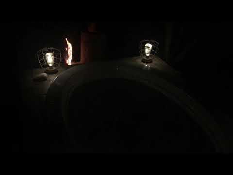 Nighttime view of hot tub and rocket stove flame and glow