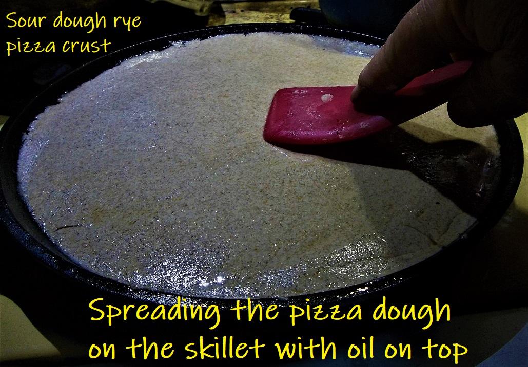 PIZZA Spreading the pizza dough on the skillet with oil on top.JPG