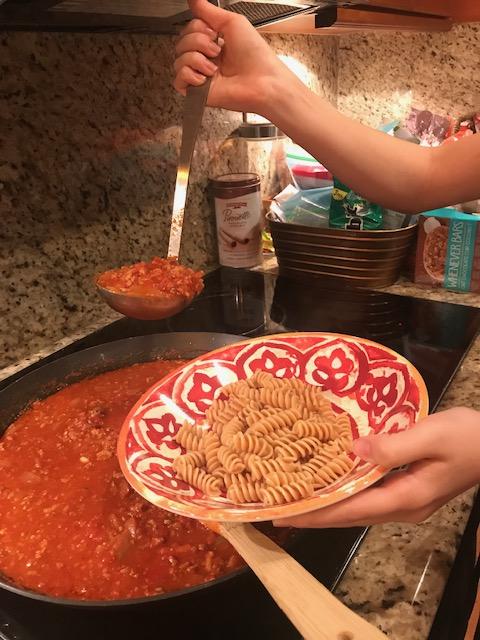 Putting sauce on pasta.jpg
