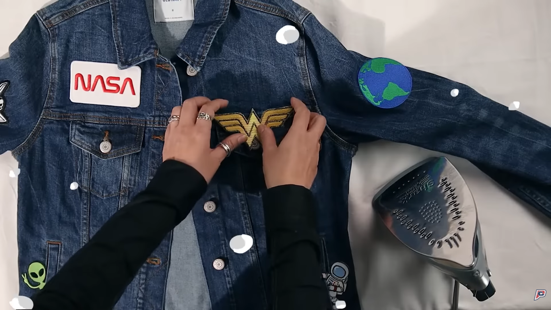 The hands placing the Wonder Woman patch.png