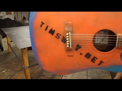 beating up a 5-string guitar while making a coffee table