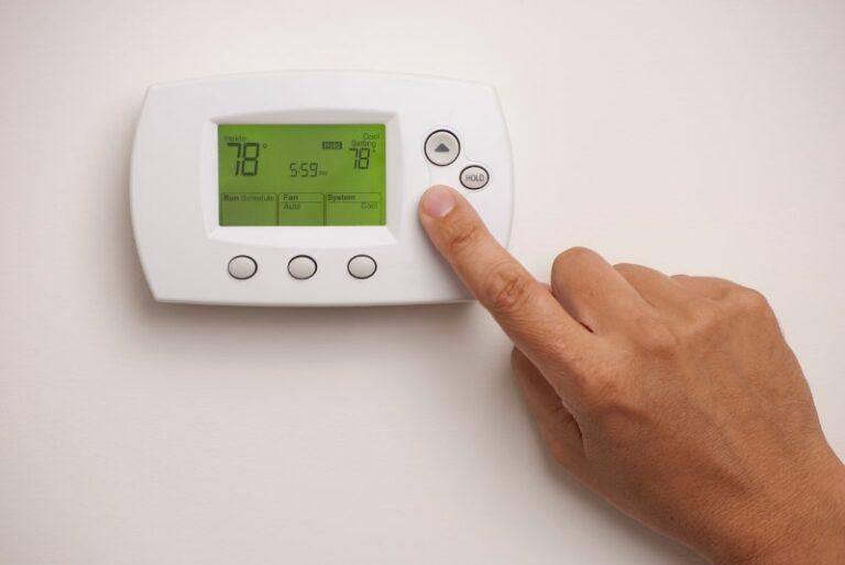 finger-pressing-white-thermostat-button-768x514.jpg