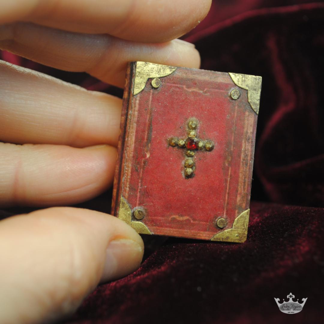 miniature red book with gem cross and gold corners.jpeg